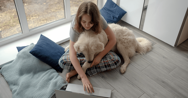 Une femme assise faisant un câlin à son chien.